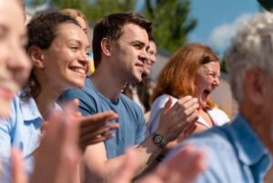 People clapping with focus on young man